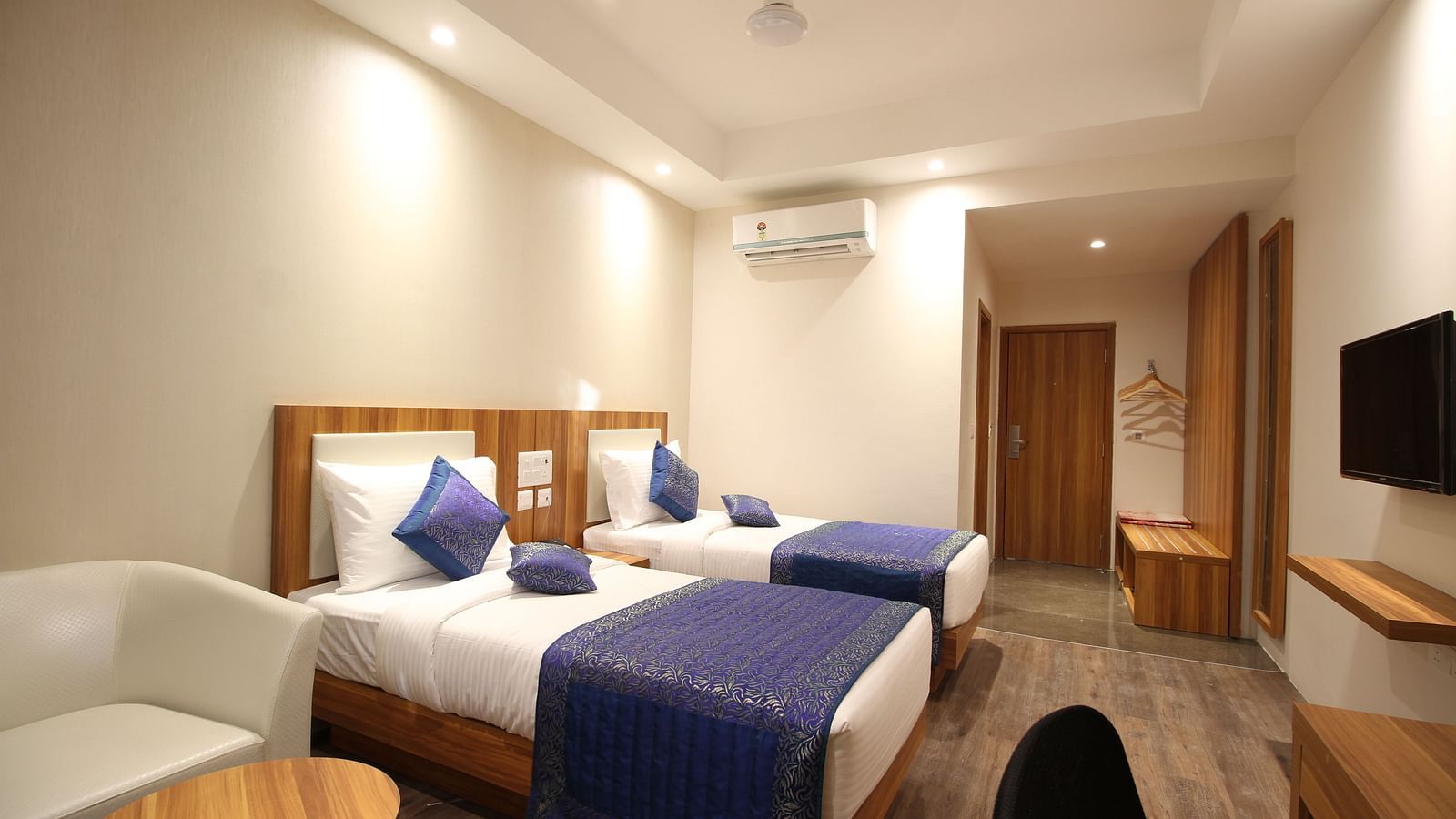 deluxe room with twin beds captured from different angles that showcase the in-room amenities and interior of the bedroom - le roi raipur hotel1