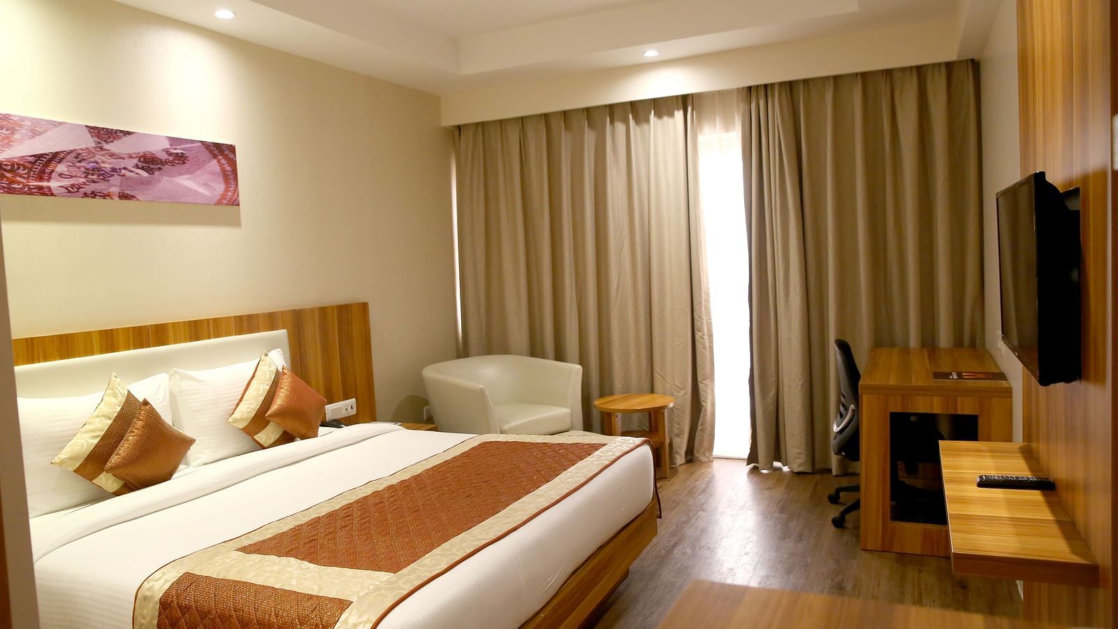 Premium Golden Rooms with Balcony showcasing the modern bedroom with contemporary lighting along with in-room amenities - le roi udaipur hotel5