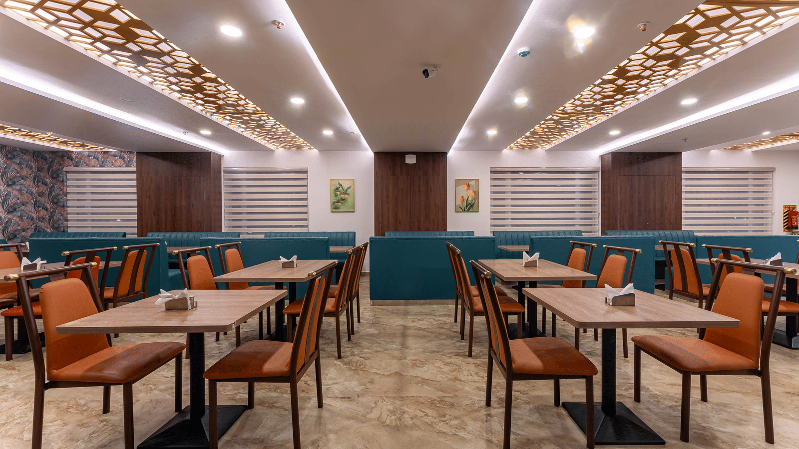 The Amirtham Restaurant of Le Royale Palace with neatly arranged chairs and tables, and elegant ceiling lights