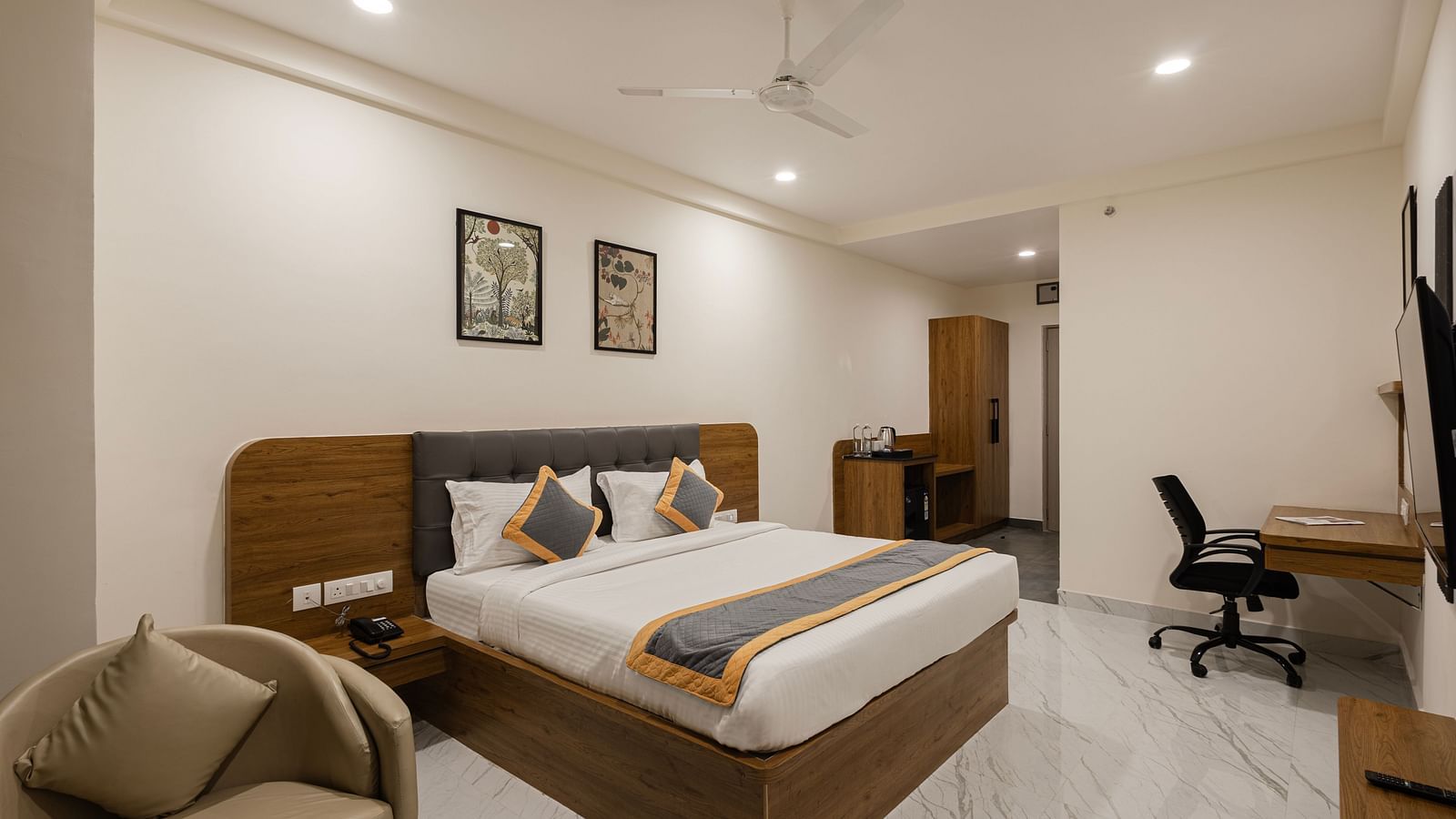 Well-furnished guest room with desk, chair, and king-size bed at Lemonridge Hotels, IDPL Balanagar.
