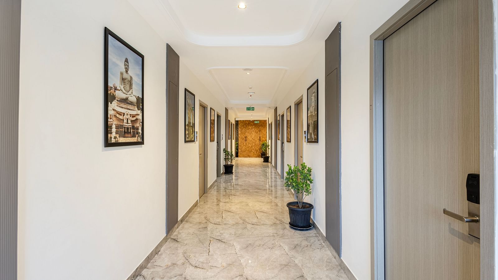 Well-lit hotel corridor with decorative art and marble flooring at Lemonridge Hotels.