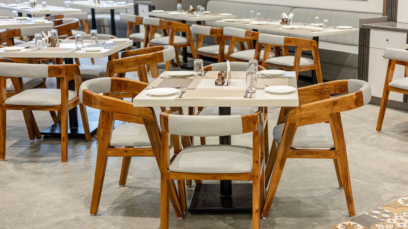 Wooden seating and sleek arrangement in the restaurant at Lemonridge Hotels, IDPL Balanagar