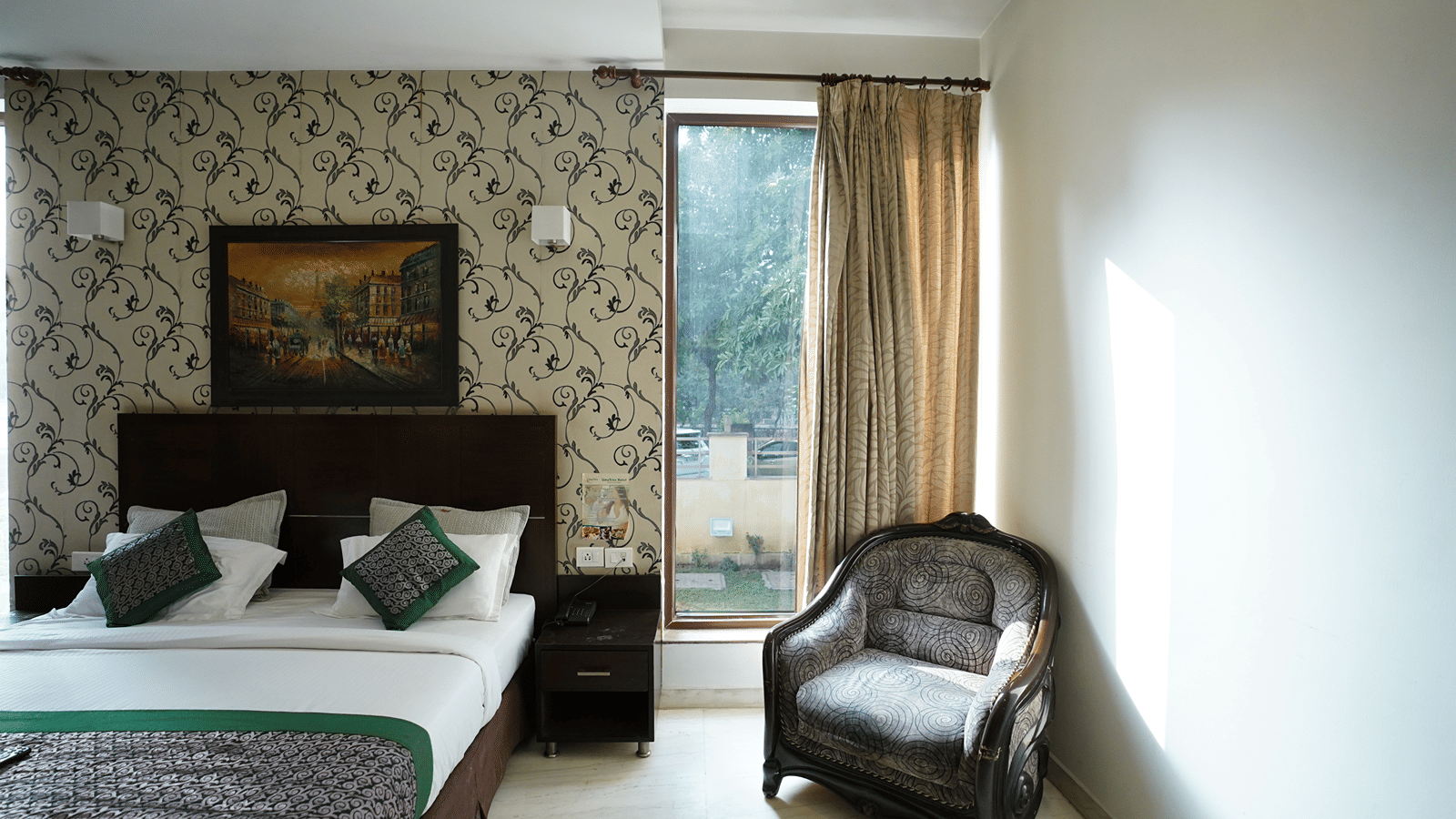 Double bed with fresh linens, a cosy armchair, elegant décor and a balcony bringing natural light into the room.