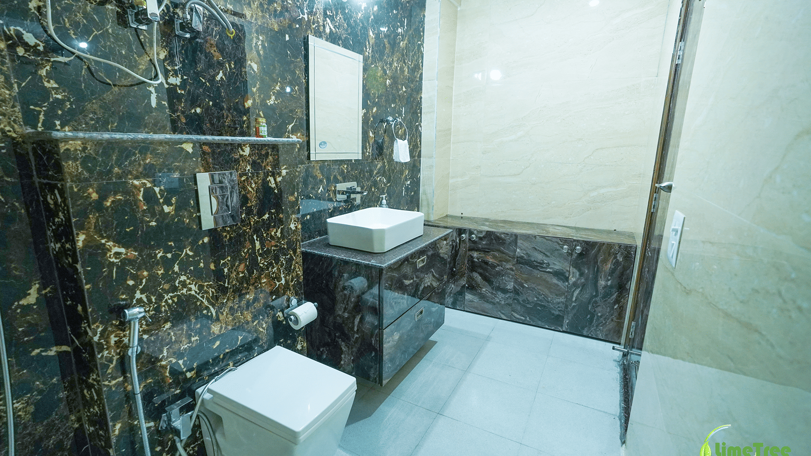 Bathroom with black and gold marble walls and a glass shower partition at Lime Tree Hotel Near 32nd Avenue.