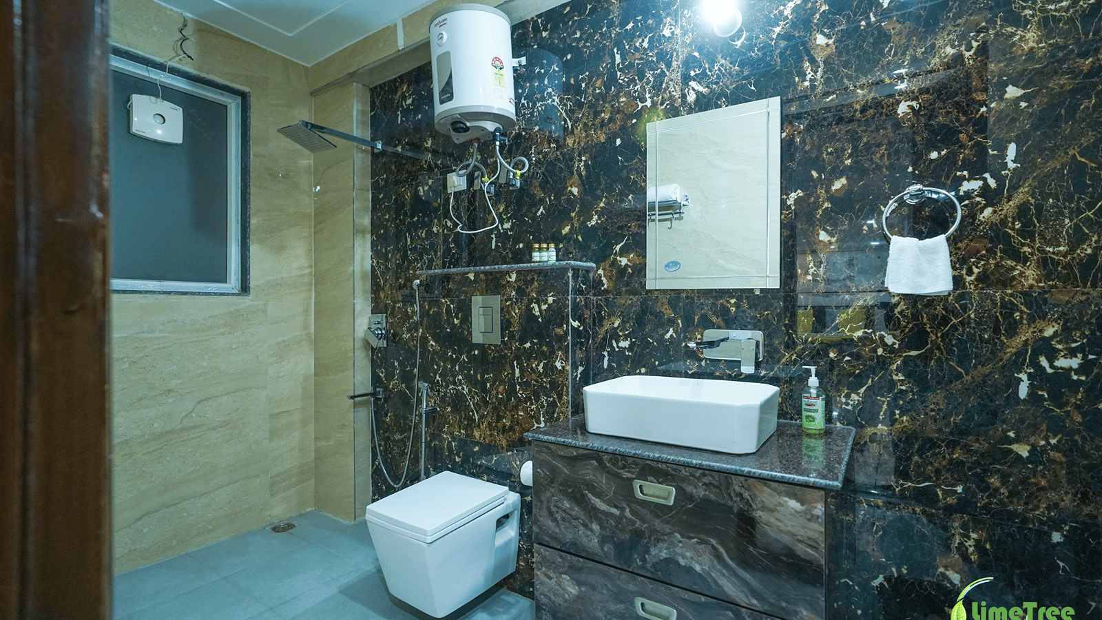 Bathroom with black and gold marble walls, a vessel sink and mirror at Lime Tree Hotel Near 32nd Avenue.