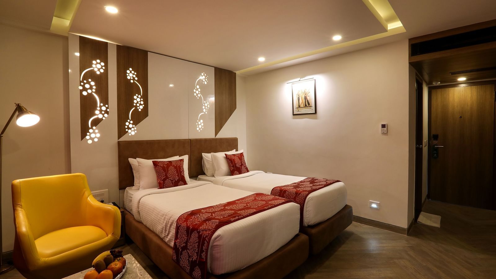 A bedroom with two single beds and a sofa and small table on one end beside the windows - Mango Hill Central, Chennai