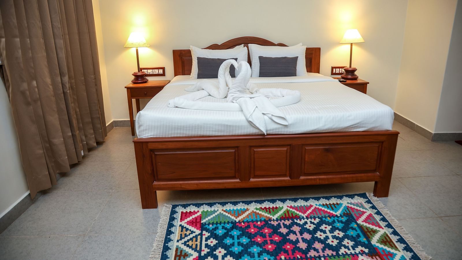 A room with double-sixed bed, lamp on either side, and a window covered by a curtain | Mango HIll La Serene, Ponicherry