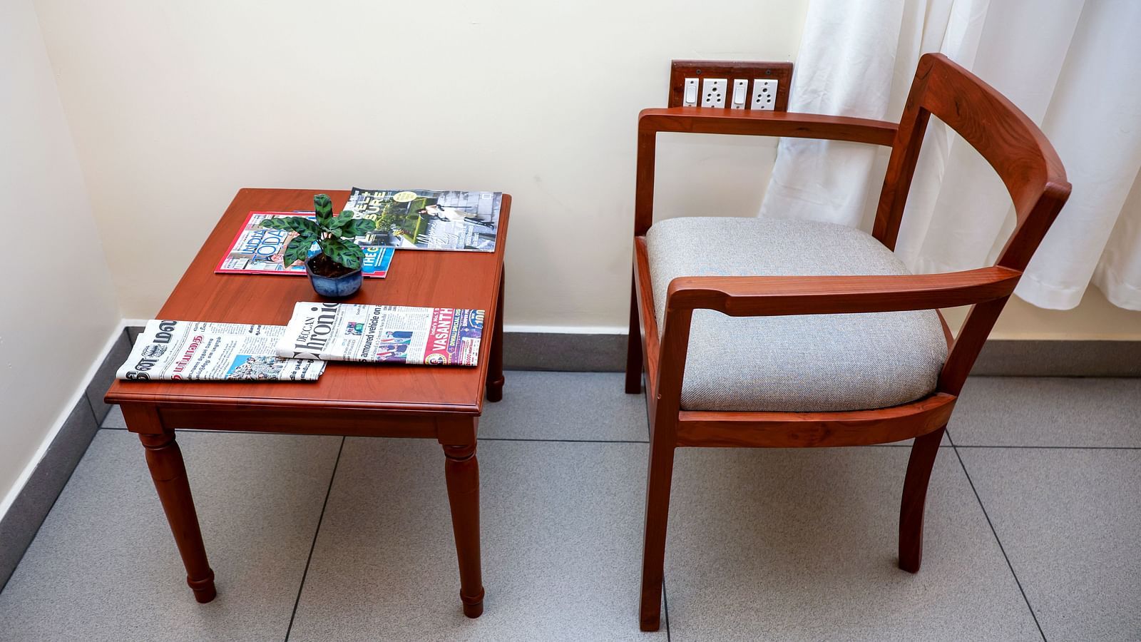 A table and a chair placed at one corne of a room | Mango Hill La Serene, Pondicherry