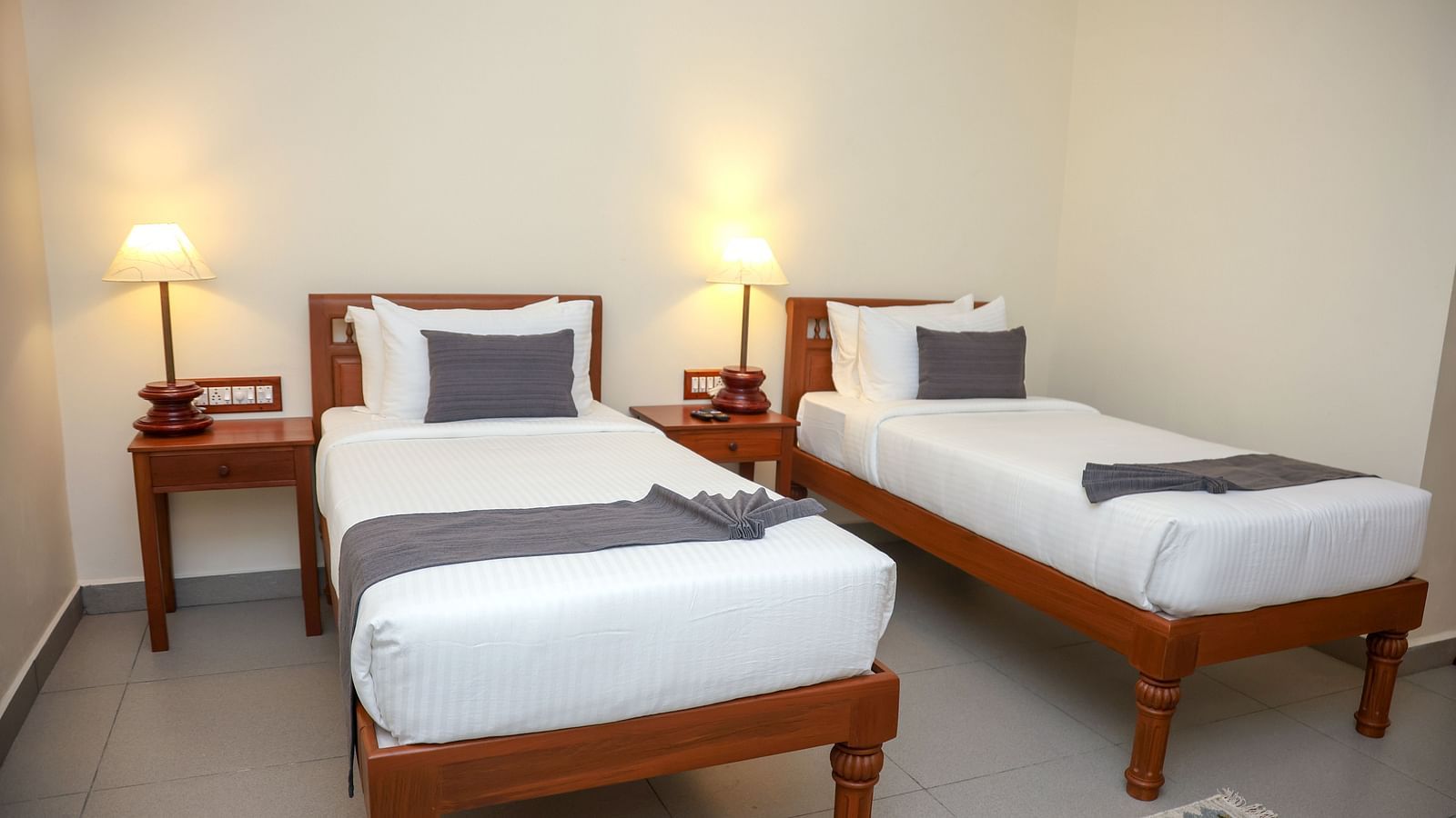 A room that has two similar looking bed with a bedside table beside them  | Mango HIll La Serene, Ponicherry