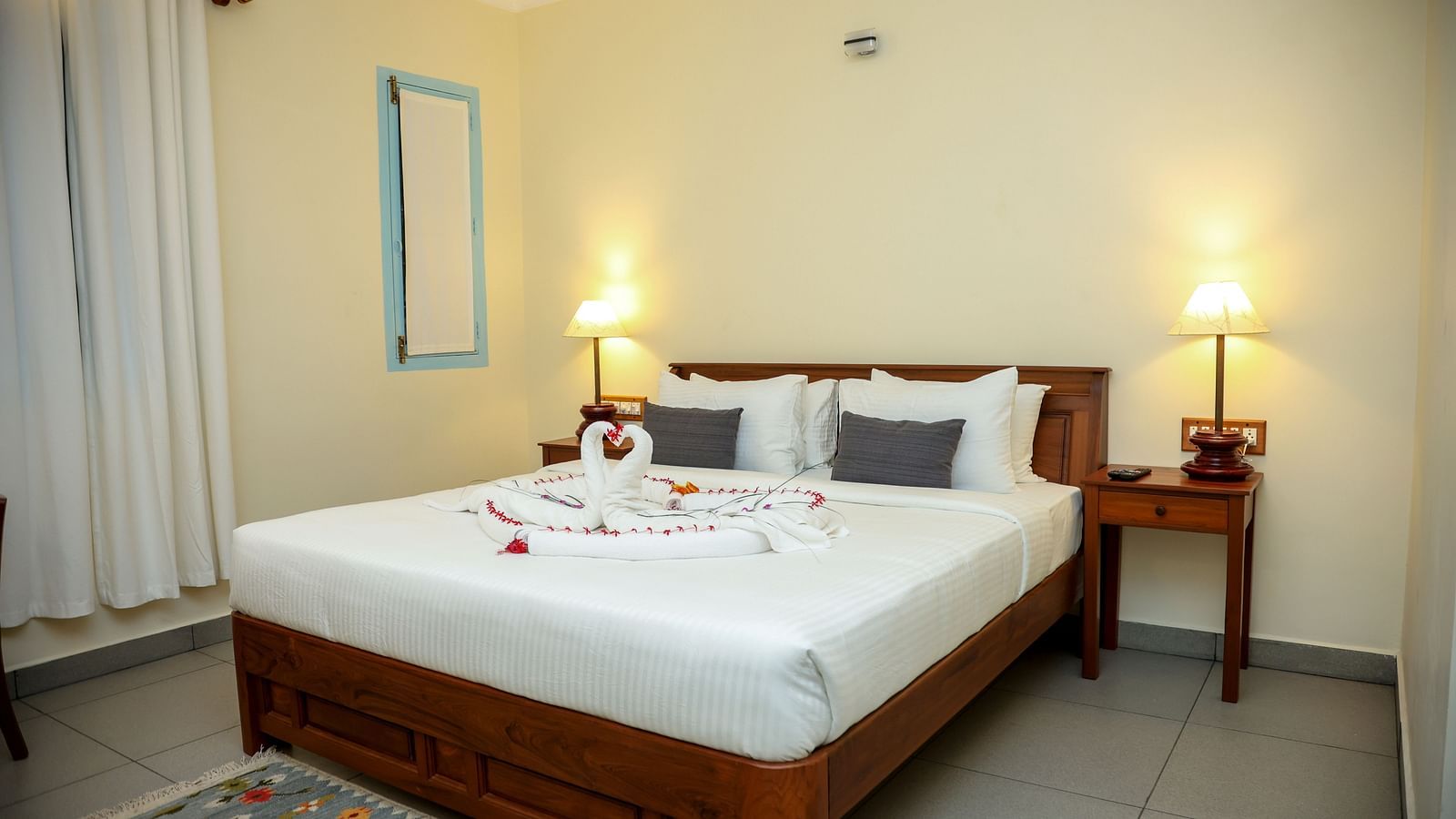 A bedroom which has a bed decorated by towel swans | Mango Hill La Serene, Pondicherry