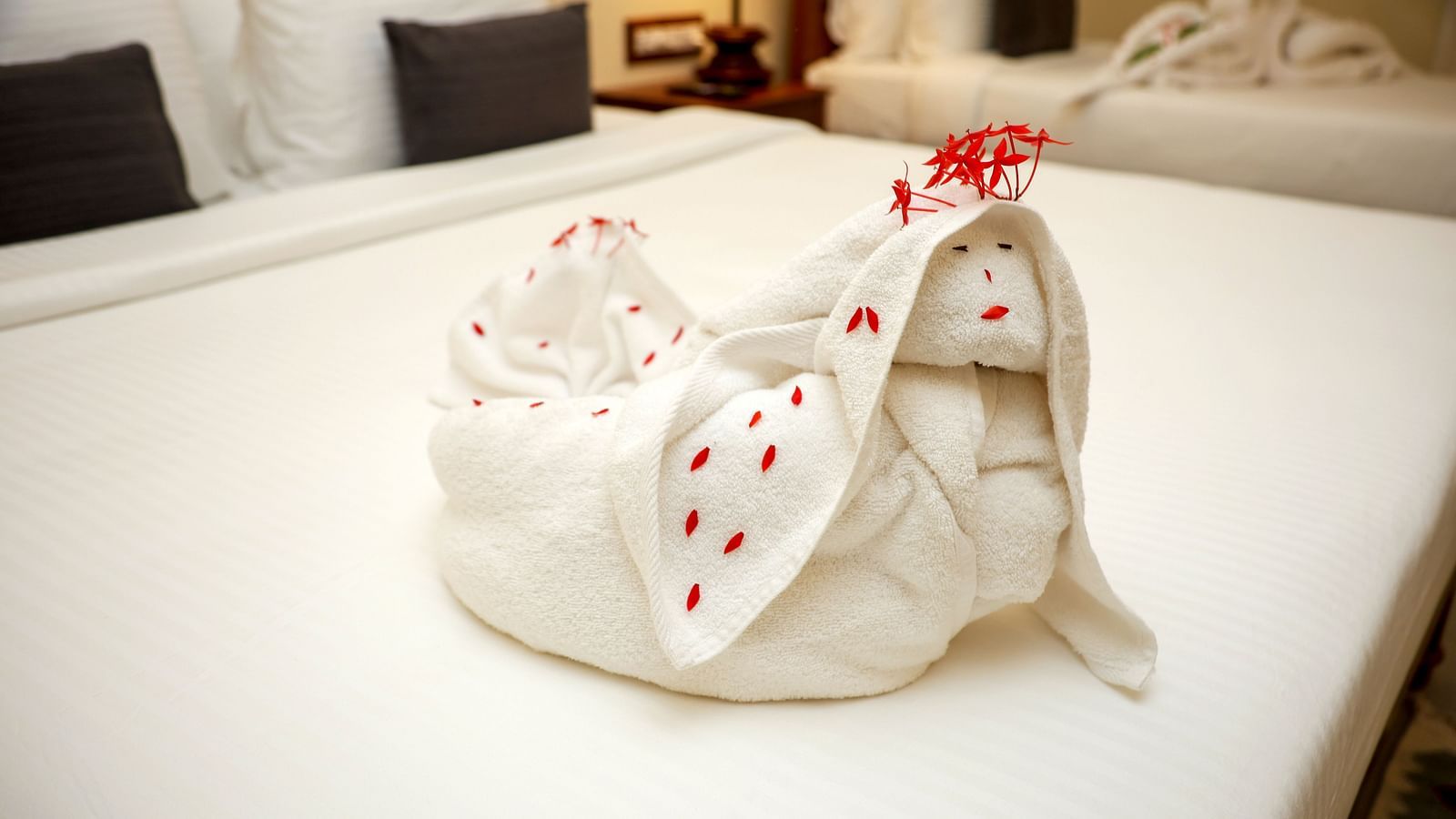 A bed decorate with towels and few flower petals  | Mango Hill La Serene, Pondicherry
