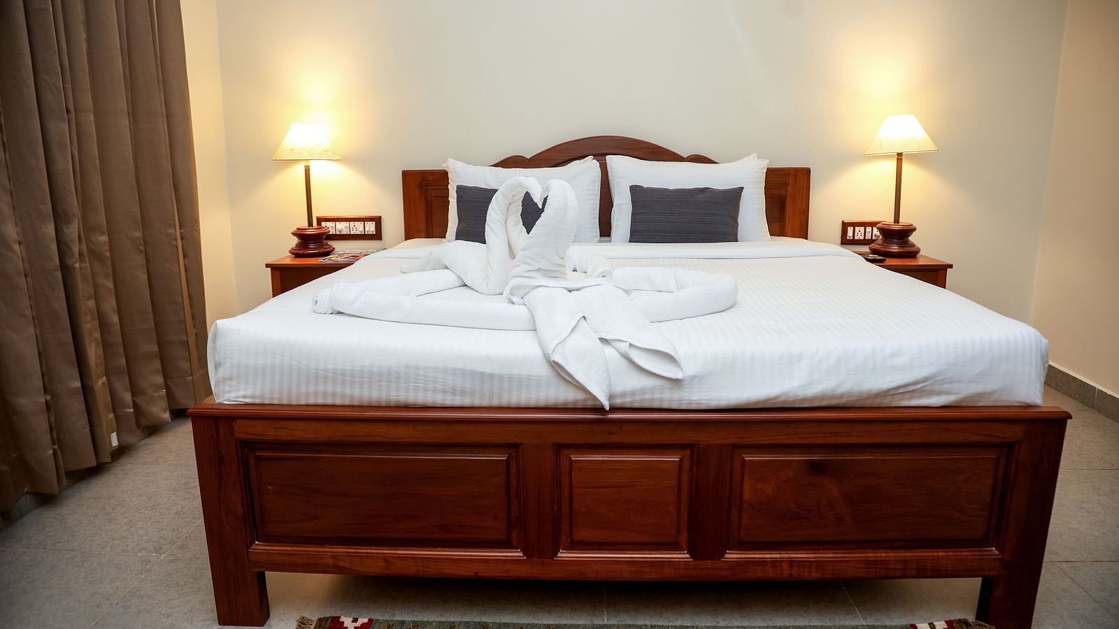 A bed that has two swans made out of towels at Mango Hill La Serene, Pondicherry