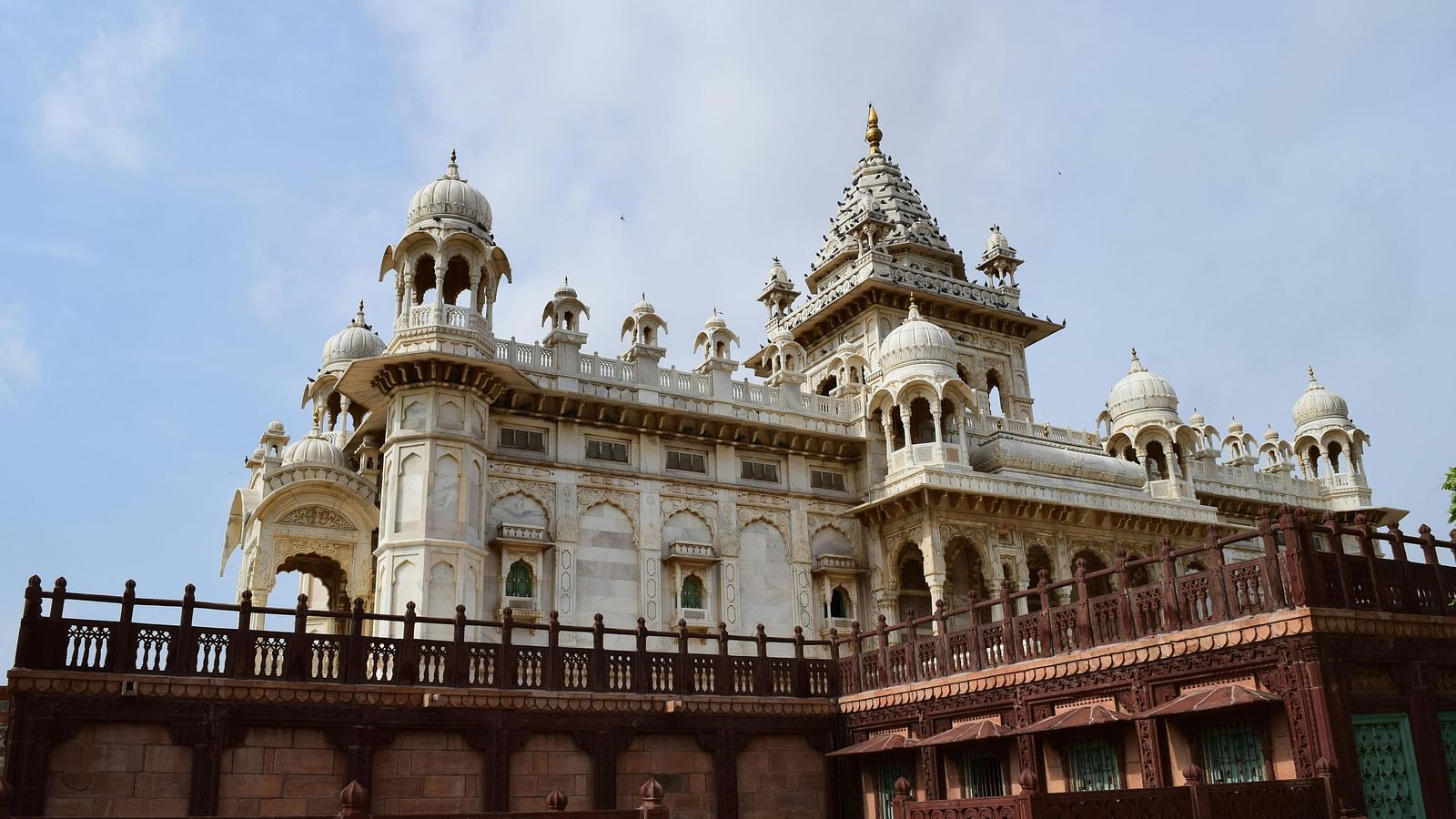 facade image of the regal white structure of Jaswant Thada with a clear sky in the background 