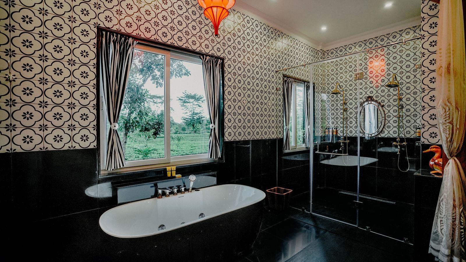 Modern bathroom with freestanding bathtub and patterned walls at MAYFAIR Tea Resort, Siliguri