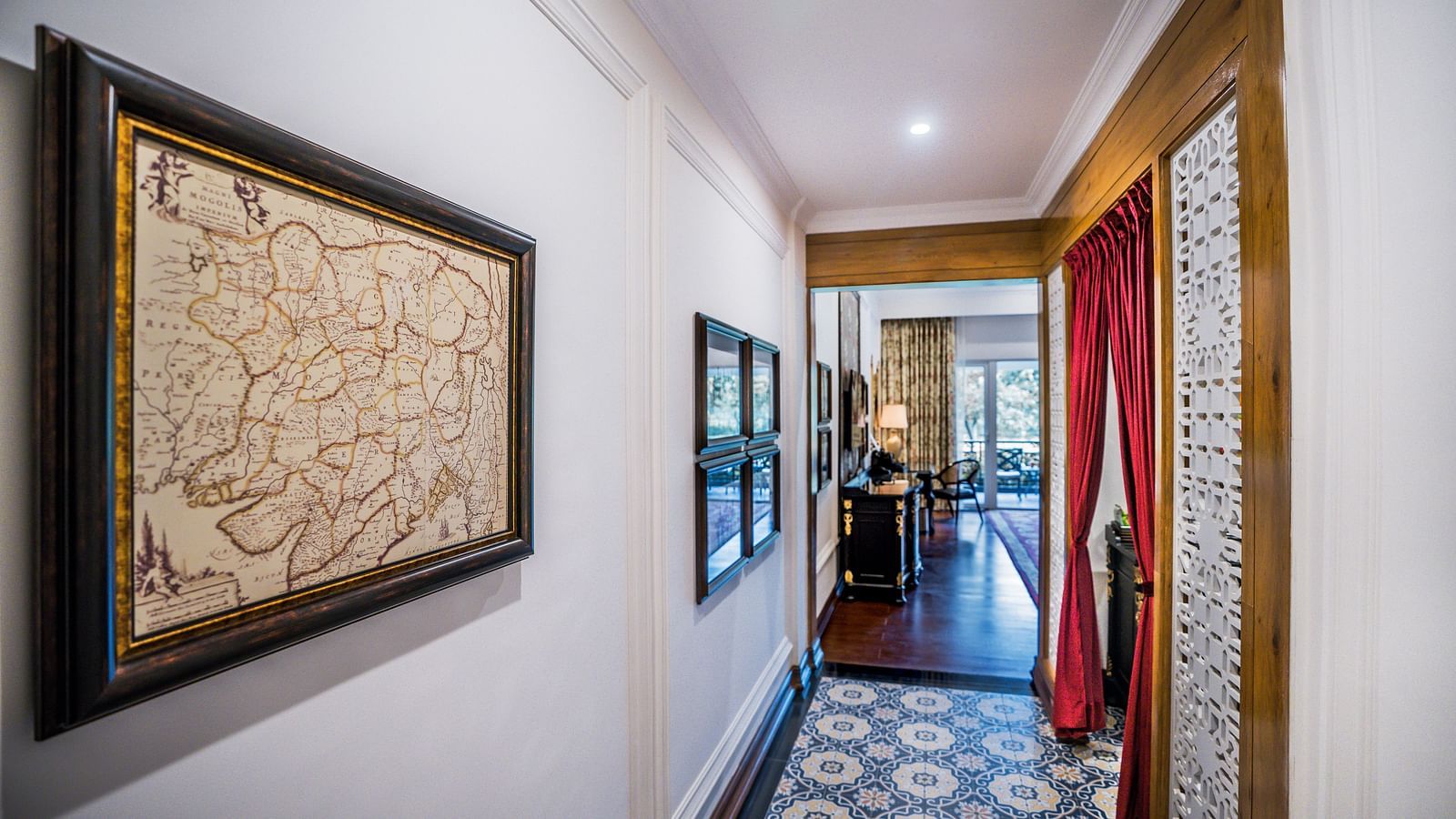 Decorated hallway with framed artwork leading to guest rooms at MAYFAIR Tea Resort, Siliguri