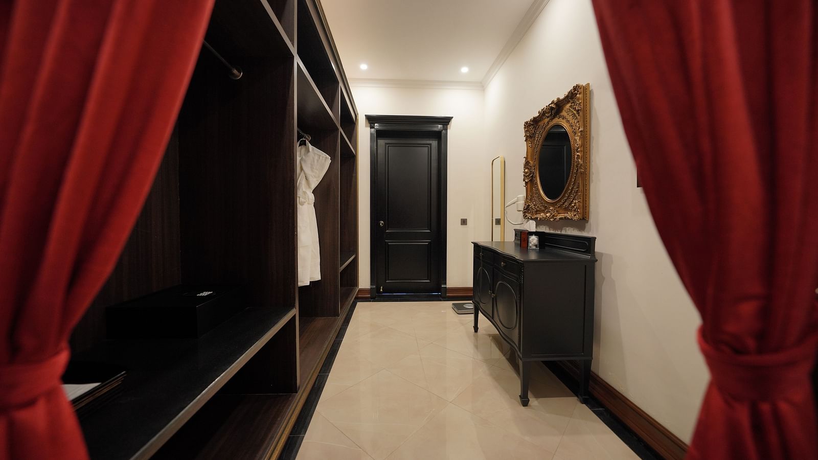 Walk-in wardrobe with red curtains and full-length mirror at MAYFAIR Tea Resort, Siliguri