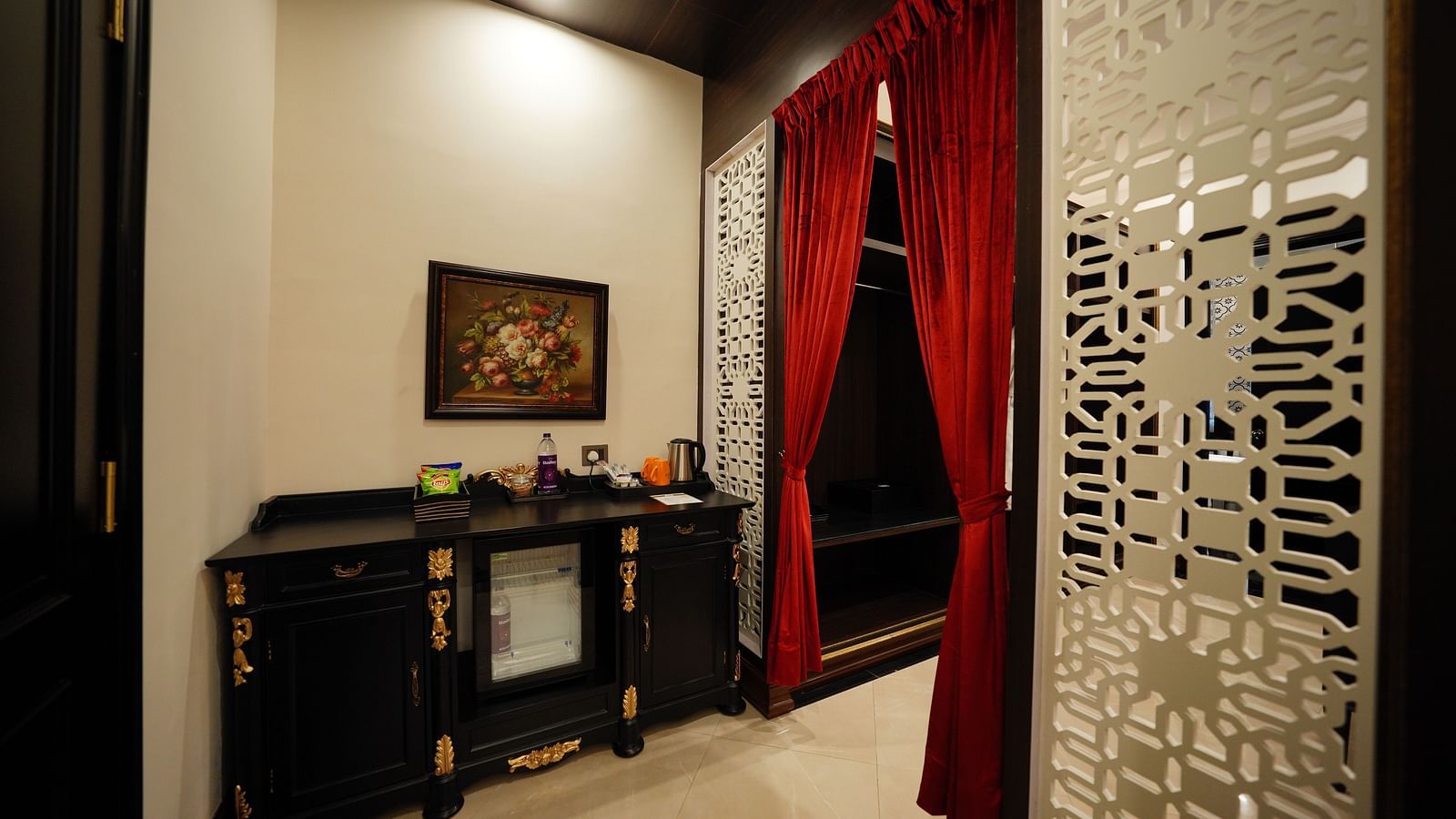 Entryway with red curtains and decorative divider in a luxury suite at MAYFAIR Tea Resort, Siliguri
