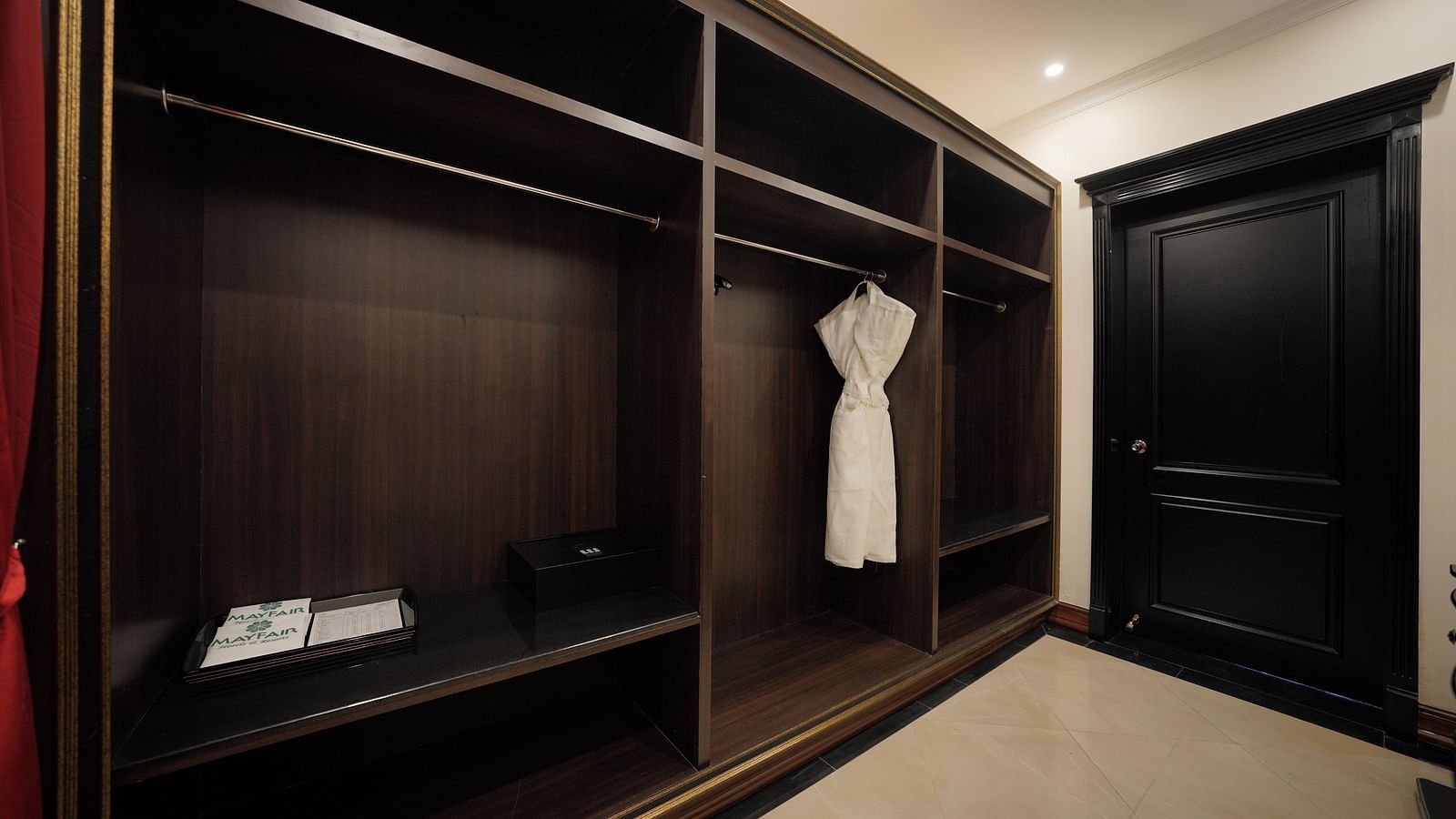 Elegant wooden wardrobe with bathrobe in a luxury suite at MAYFAIR Tea Resort, Siliguri