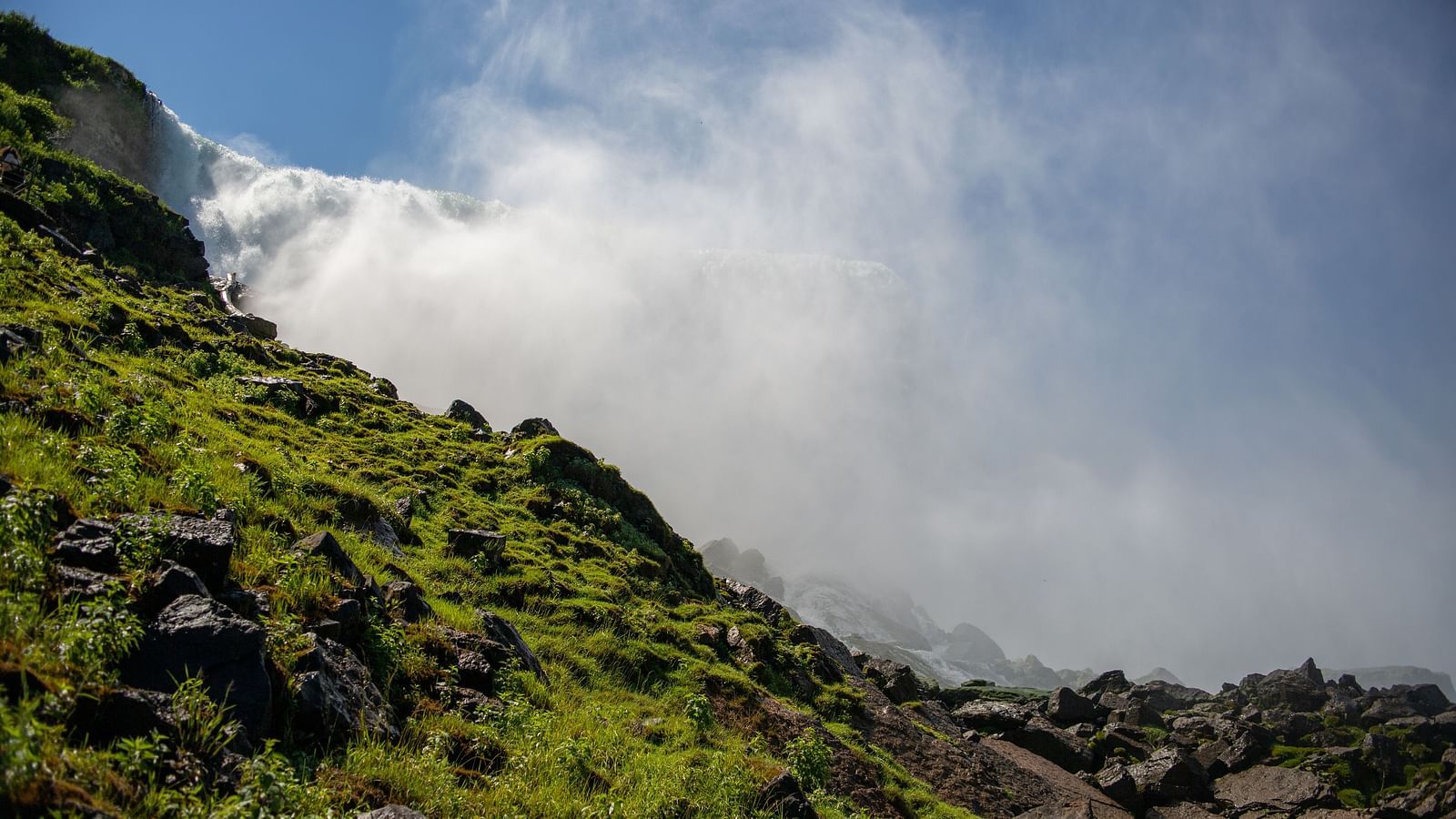  serene landscape showcasing mist from a hidden waterfall amidst rocky terrain.