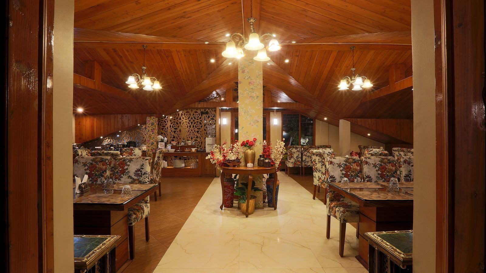 The entrance of a well-lit restaurant with empty tables and chairs | Mongas Hotel & Resort, Dalhousie