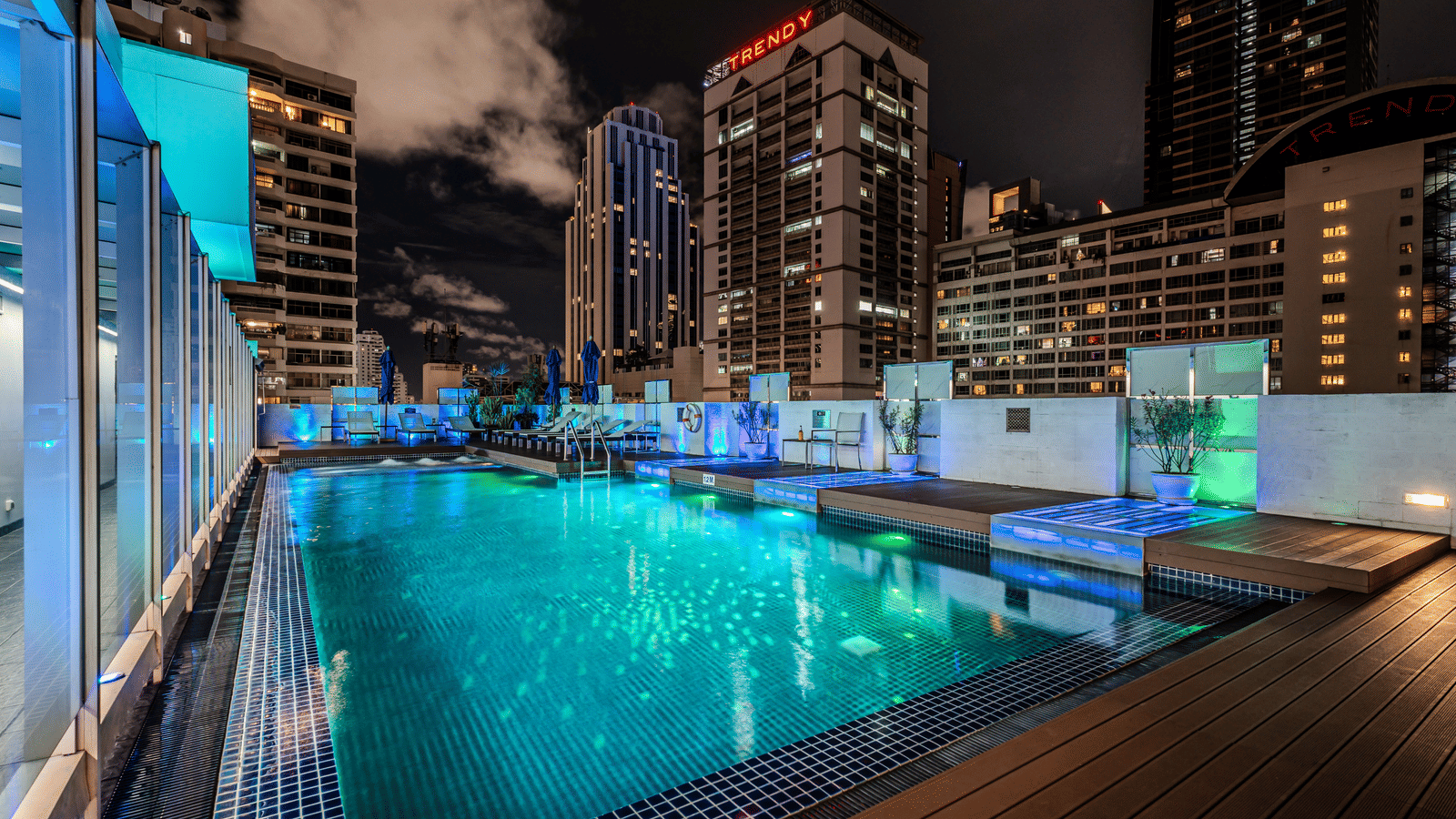 An overview of the rooftop swimming pool with the lights on  - Night Hotel Bangkok.