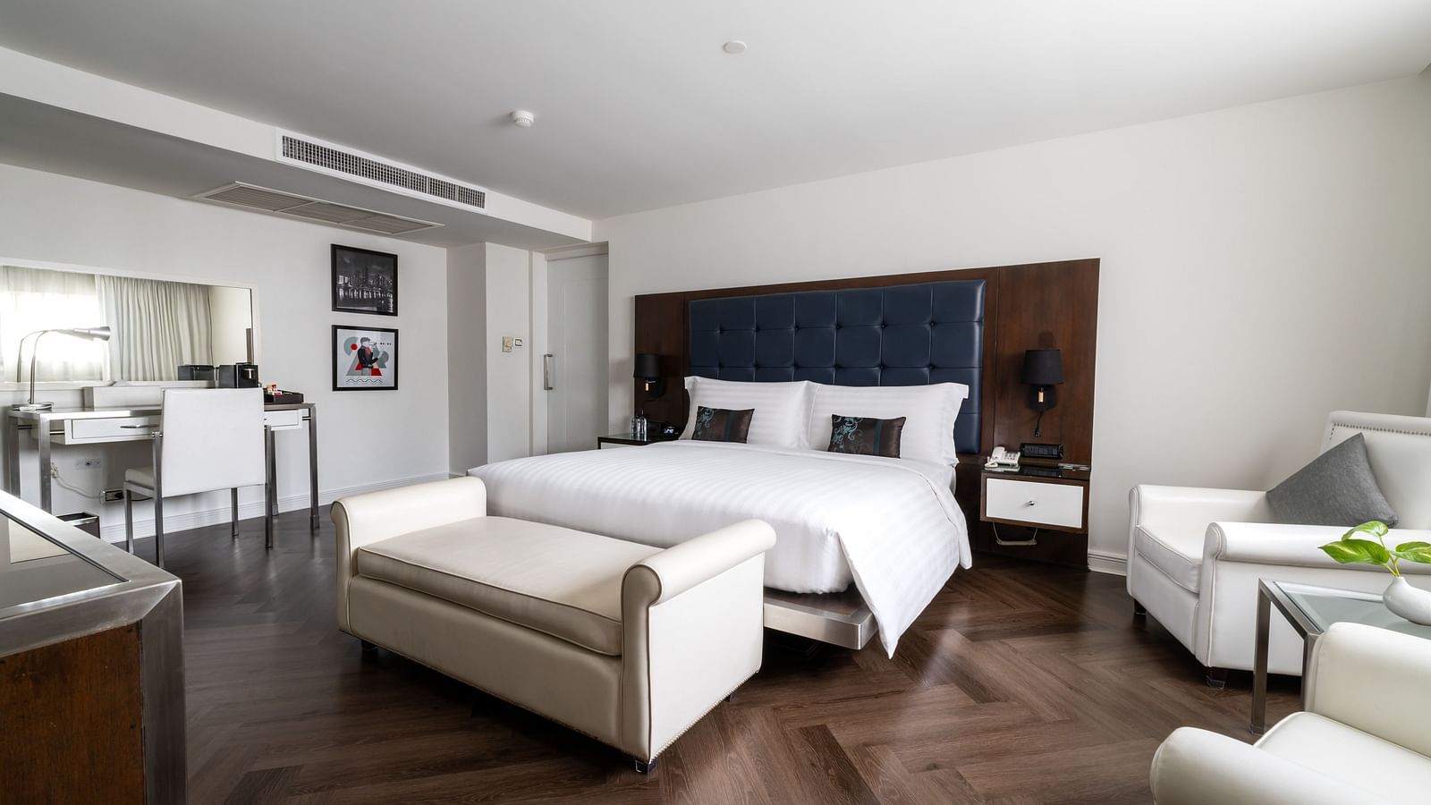 A king bed with a small sofa in front of it inside one of the rooms - Night Hotel Bangkok