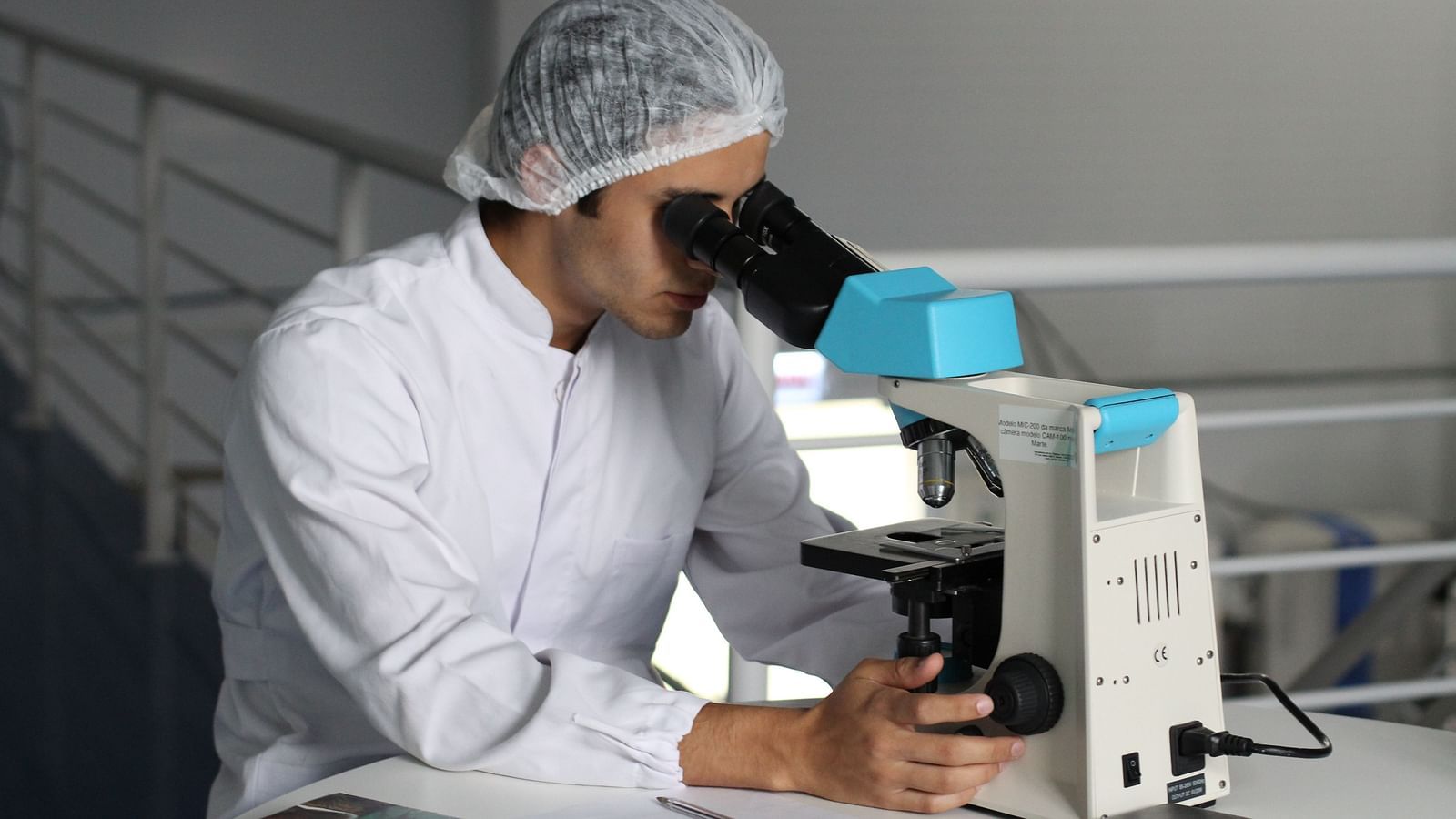 a person looking into a microscope in a laboratory.