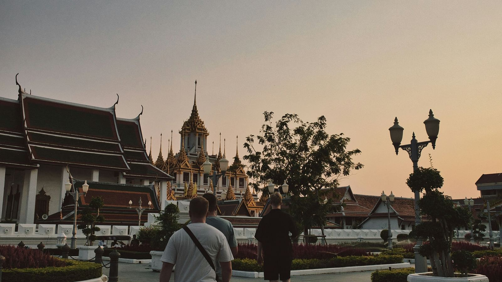 an overview of a temple in bangkok with people walking towards it.