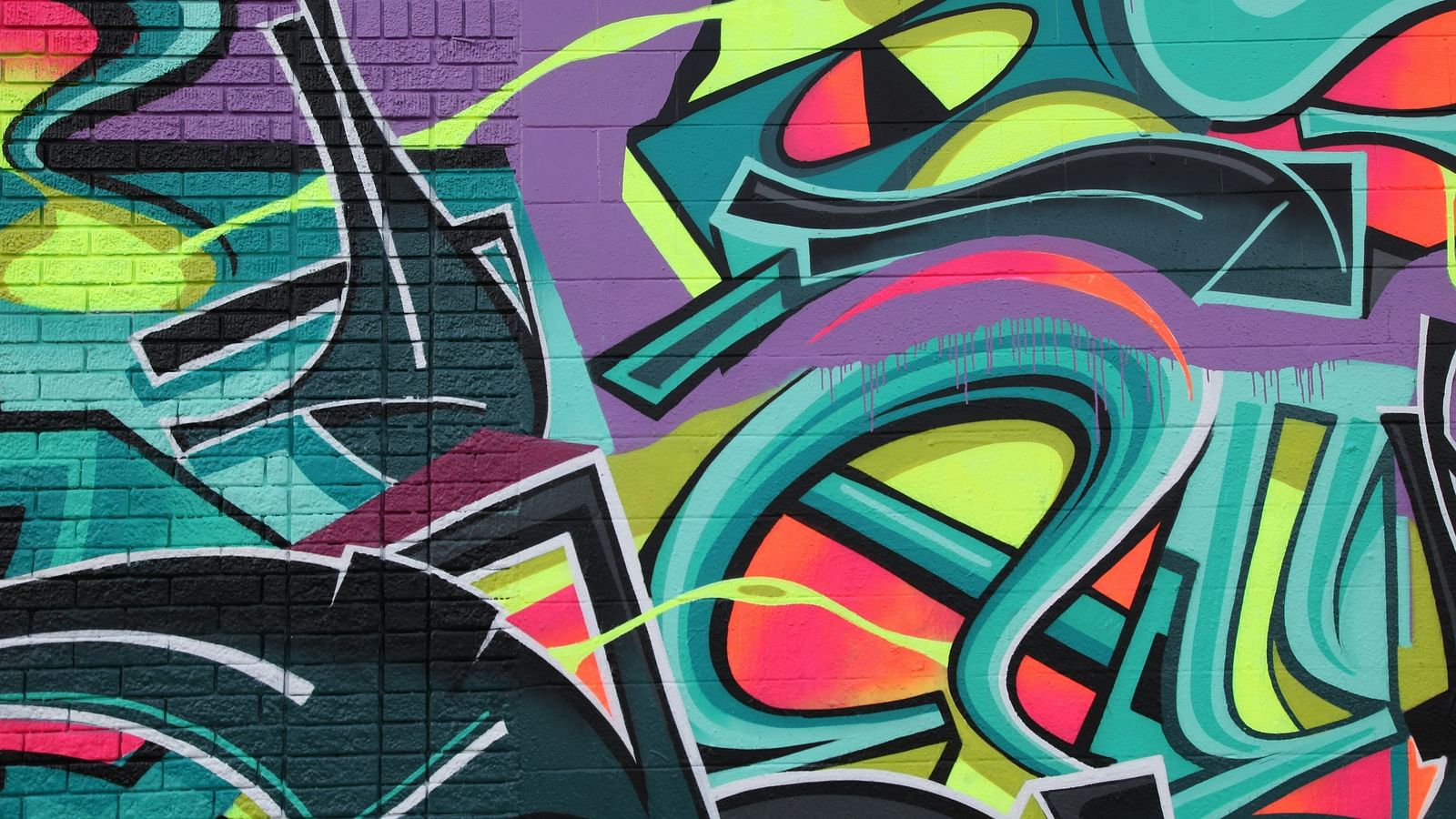 An overview of an abstract graffiti that has been painted on a wall.