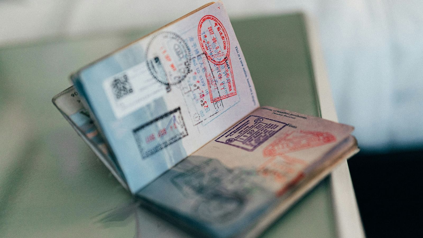a close up shot of a passport with many stamps on it kept on a table 