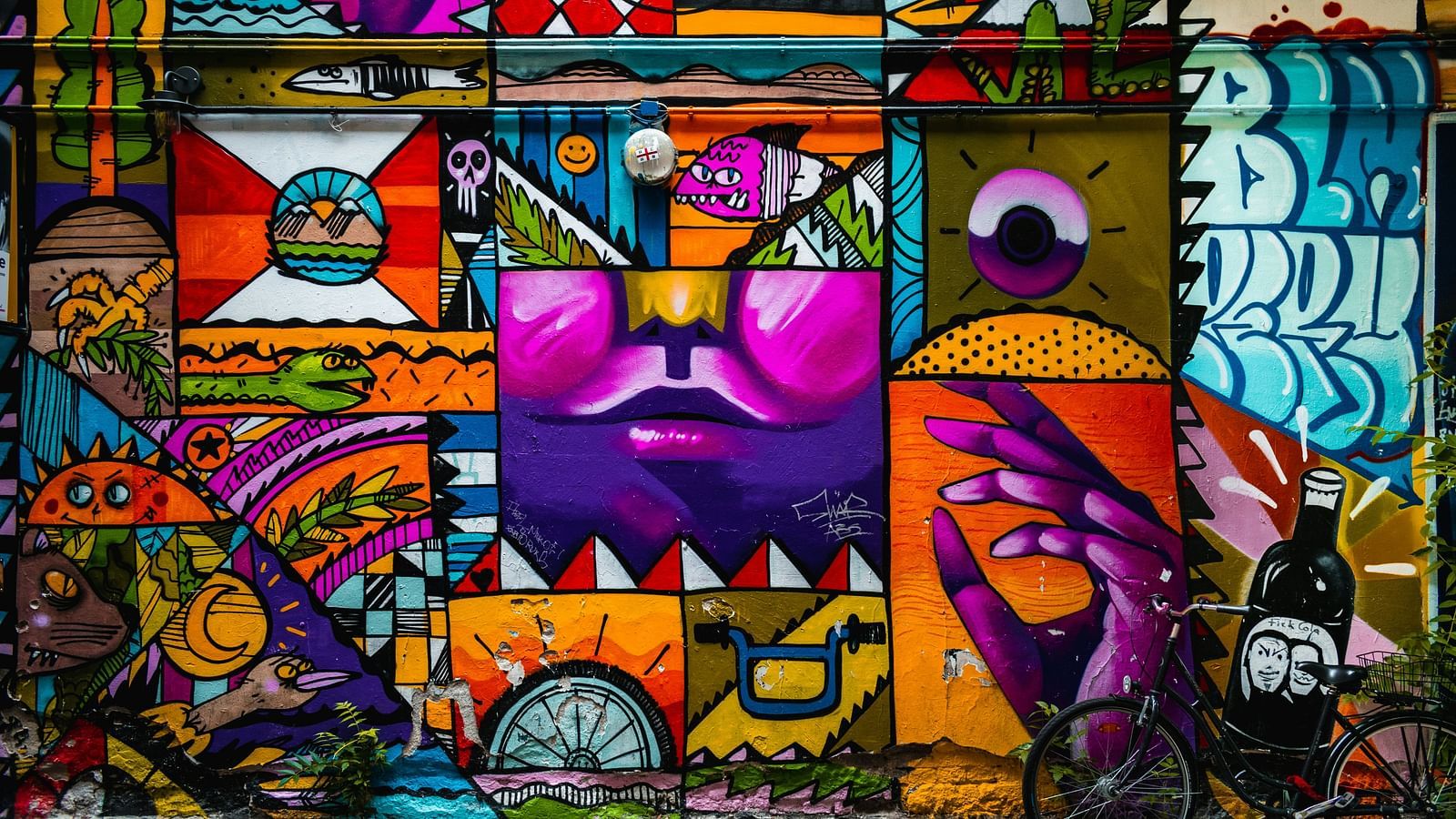 An overview of a wall mural with a bicycle parked next to the wall.