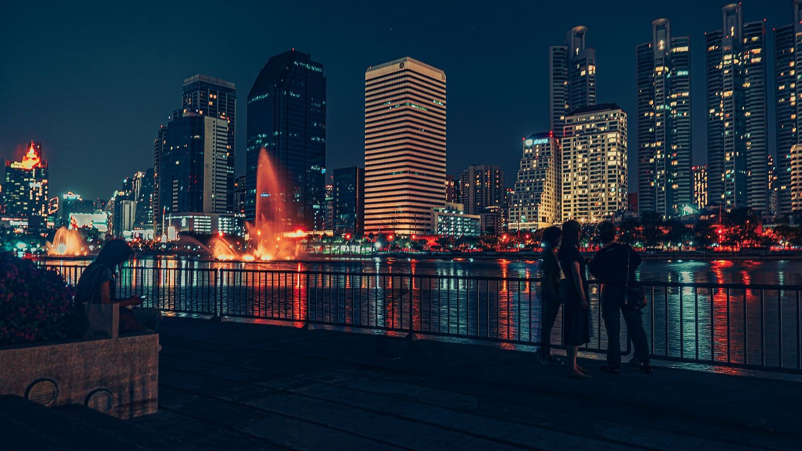 An overview of benjakitti park's viewpoint next to the lake with the skyline in view.