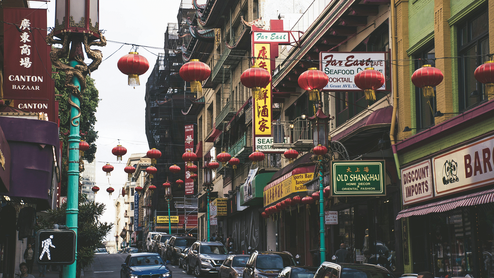 a busy street with chinese lanterns and billboards on the side of buildings