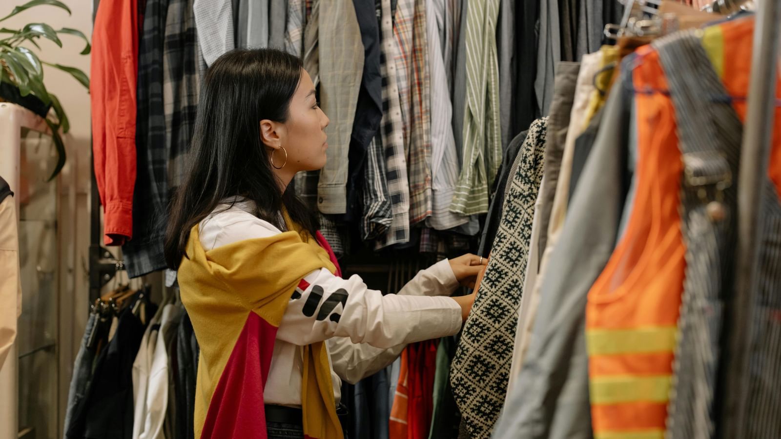 A woman surfing through a cloth rack.