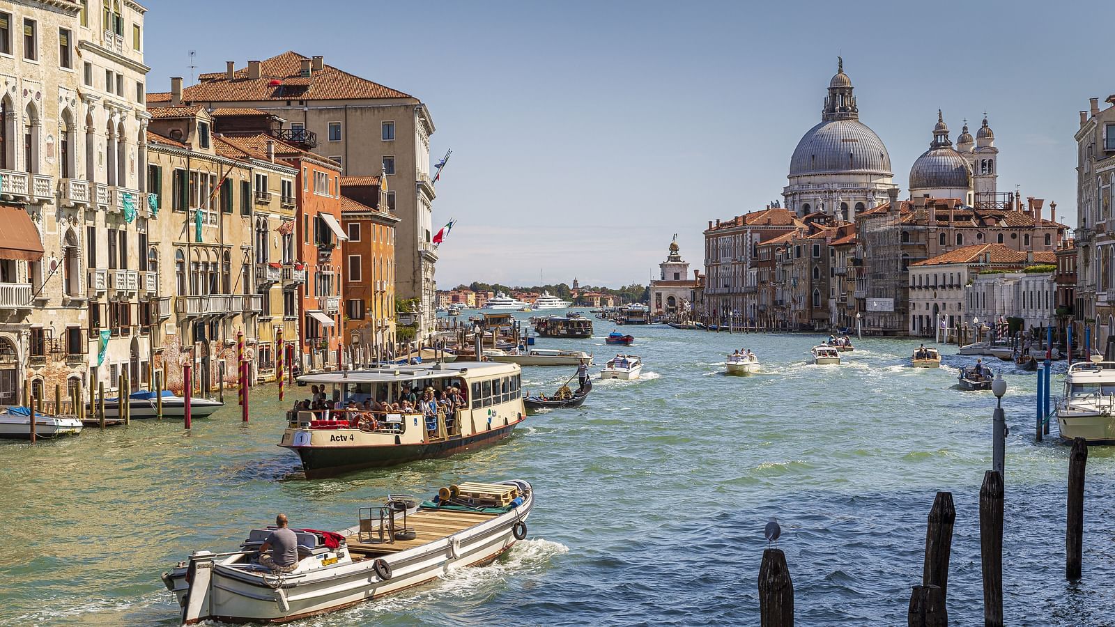 An overview of a canal system with many boats on it and buildings next to the waterbody.