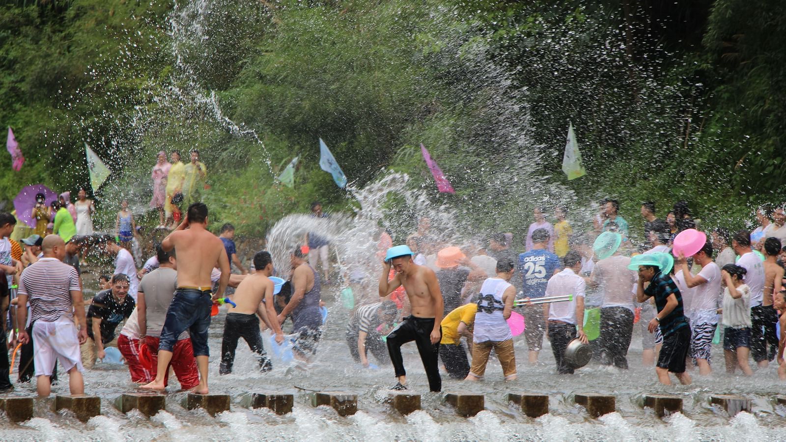 A group of people playing with water near a stream during Siam Songkran Festival in Bangkok.