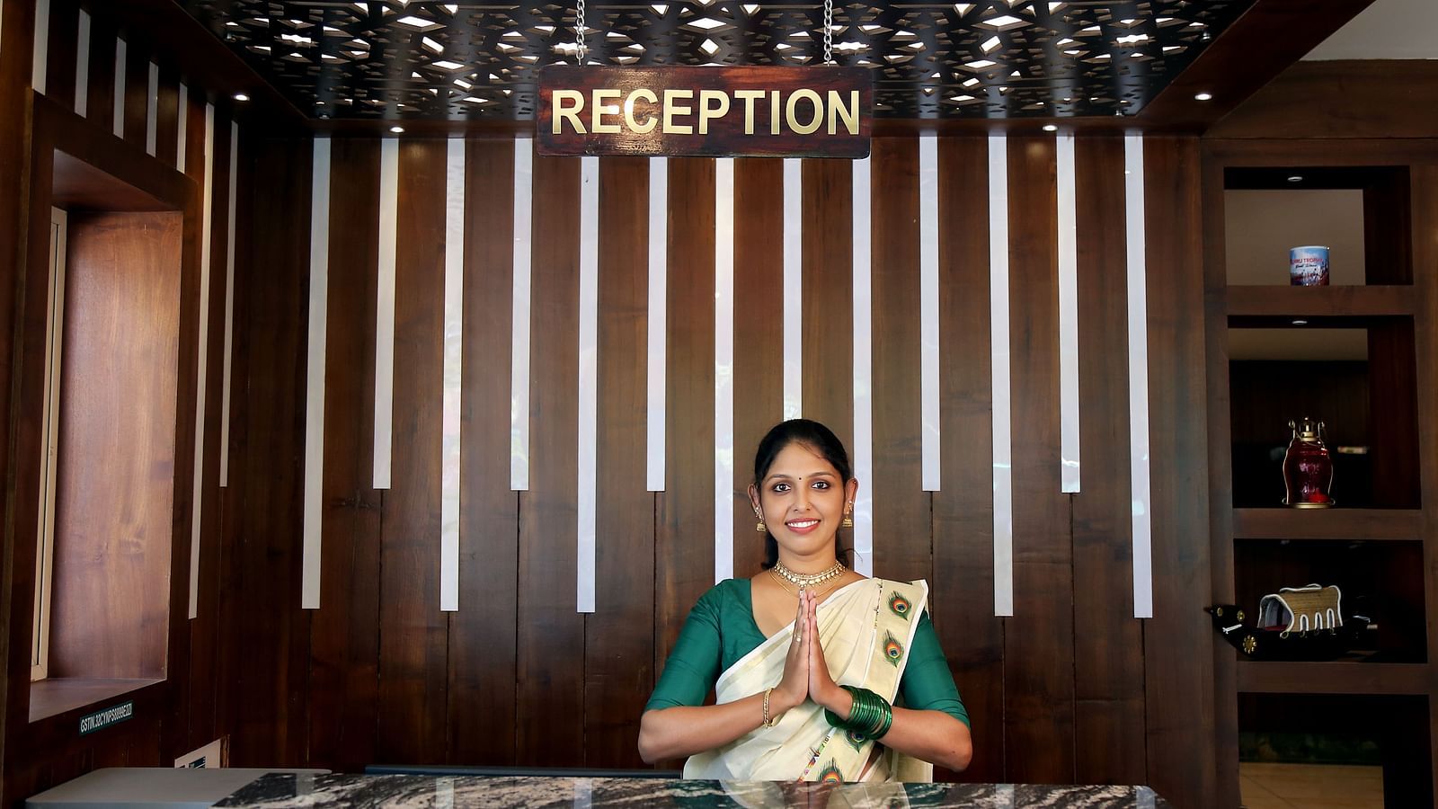 A front view of a person at desk joining her hands together