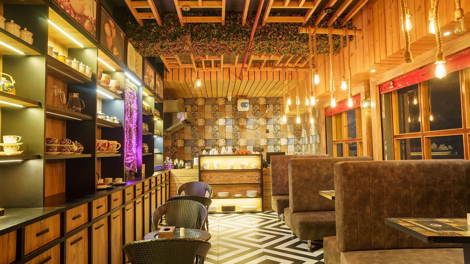 A restaurant with wooden panelled walls and ceiling, dark seating, and decorative hanging lights at Orsino Spa Resort.