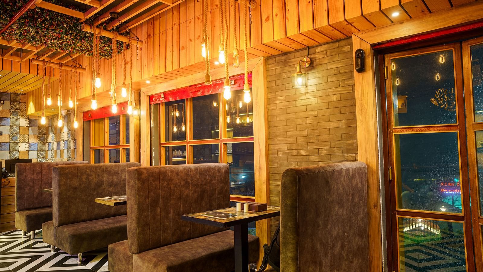 A restaurant interior with textured walls, booth seating, and decorative hanging lights at Orsino Spa Resort.