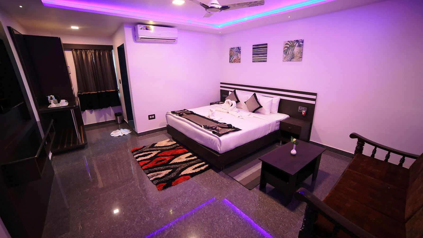 A room with a bed, a sofa, and a table on the side at Parampara Residency, Kushalnagar.