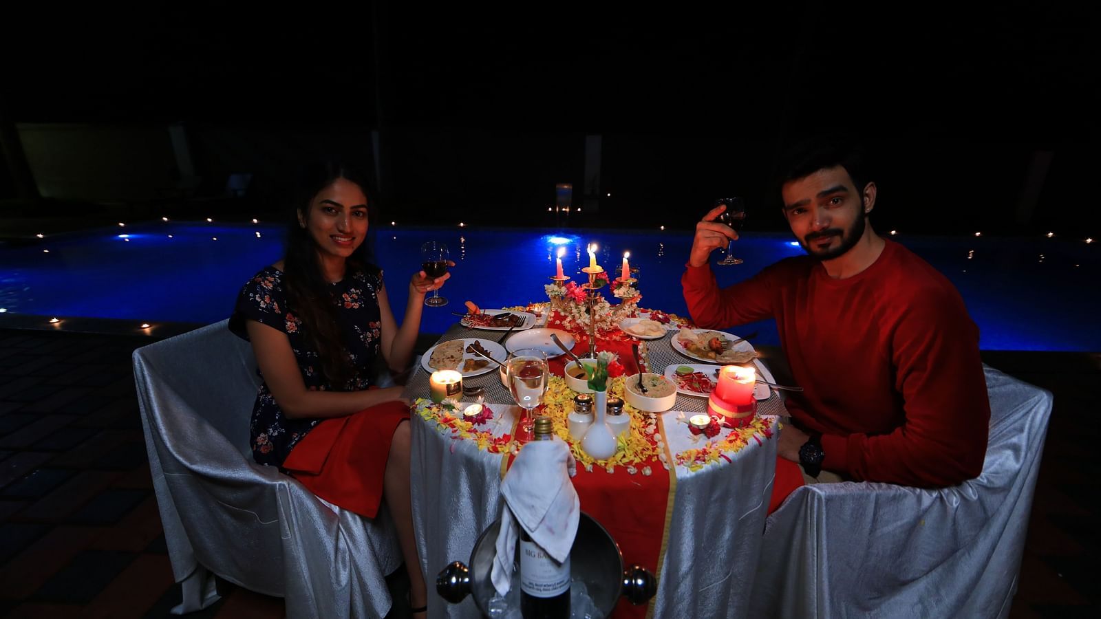 Image of two people sitting on chairs with a table filled with food in front of them at Parampara Resort & Spa, Kushalnagar.