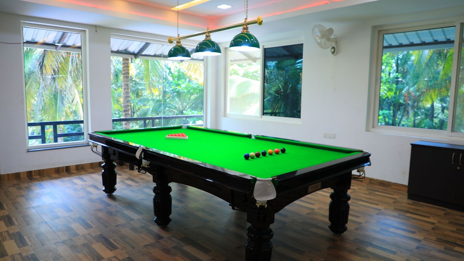 Image of a pool table with lights above it at Parampara Resort & Spa, Kushalnagar.