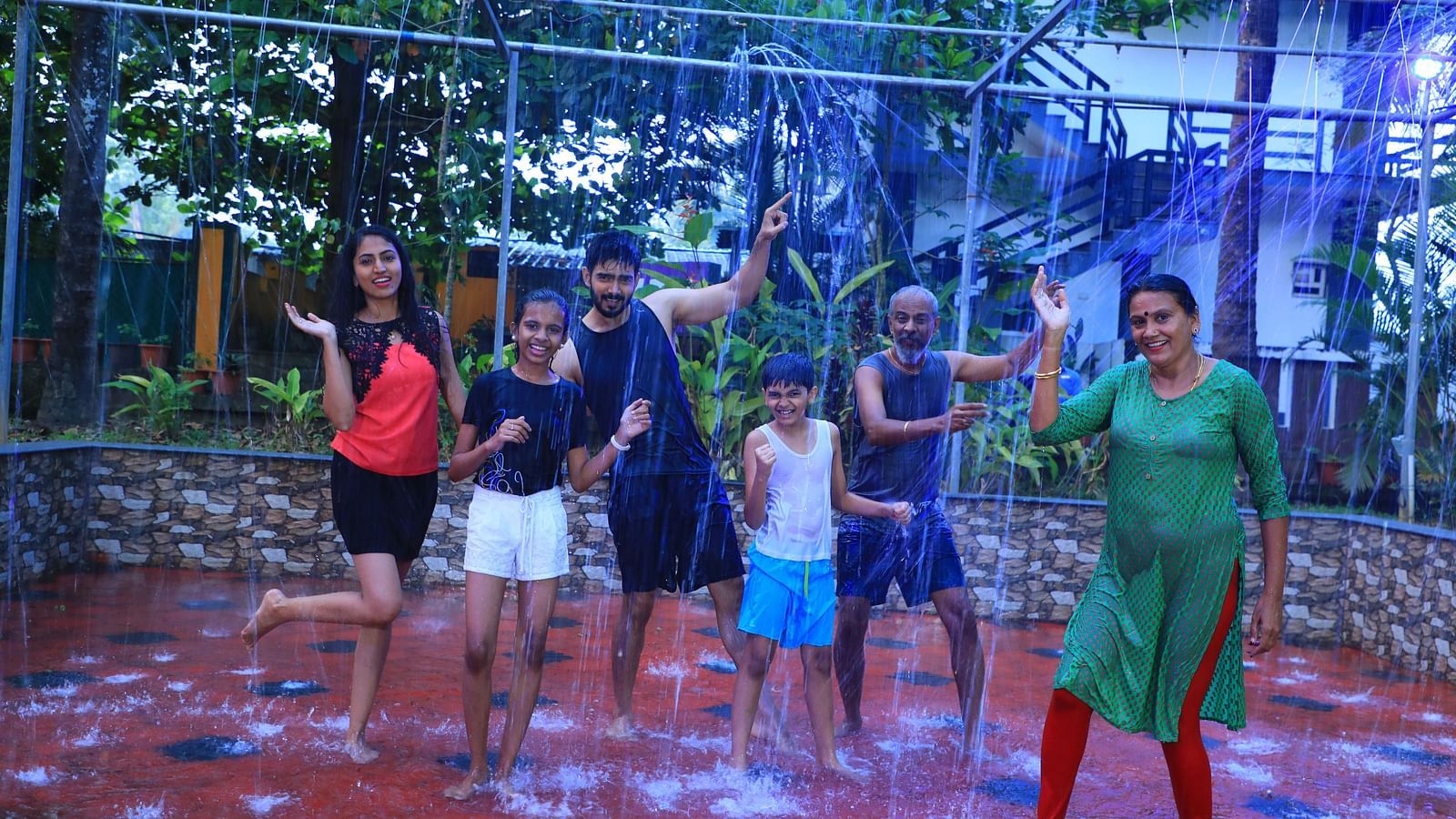 Image of a group of people taking part in a rain dance at Parampara Resort & Spa, Kushalnagar.