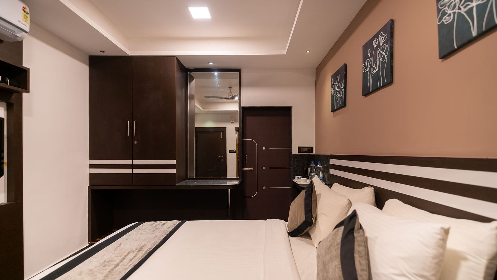 Side view of a room with a bed and a mirror on the side at Parampara Resort & Spa, Kushalnagar.