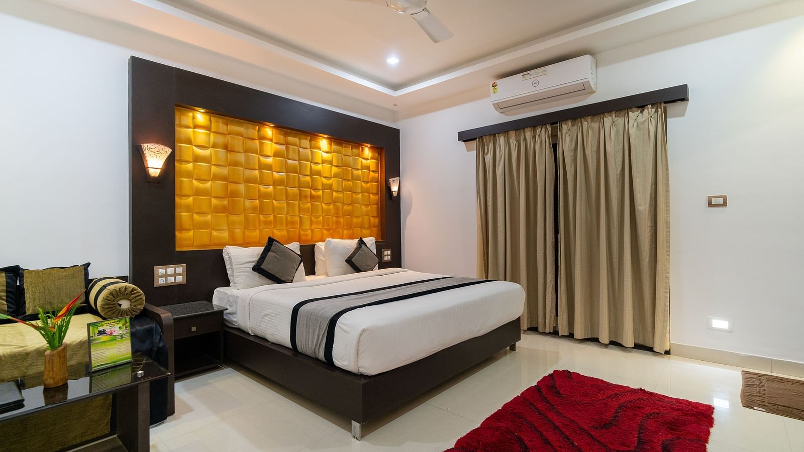 Image of a room with a bed and a sofa and a table on the side at Parampara Resort & Spa, Kushalnagar.