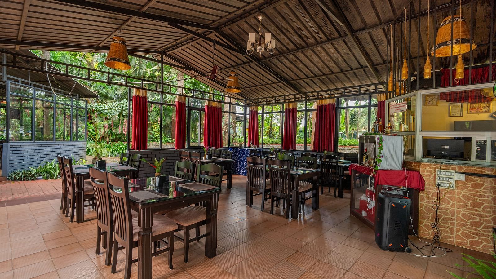 Image of a well-lit dining space with tables and chairs at Parampara Resort & Spa, Kushalnagar.