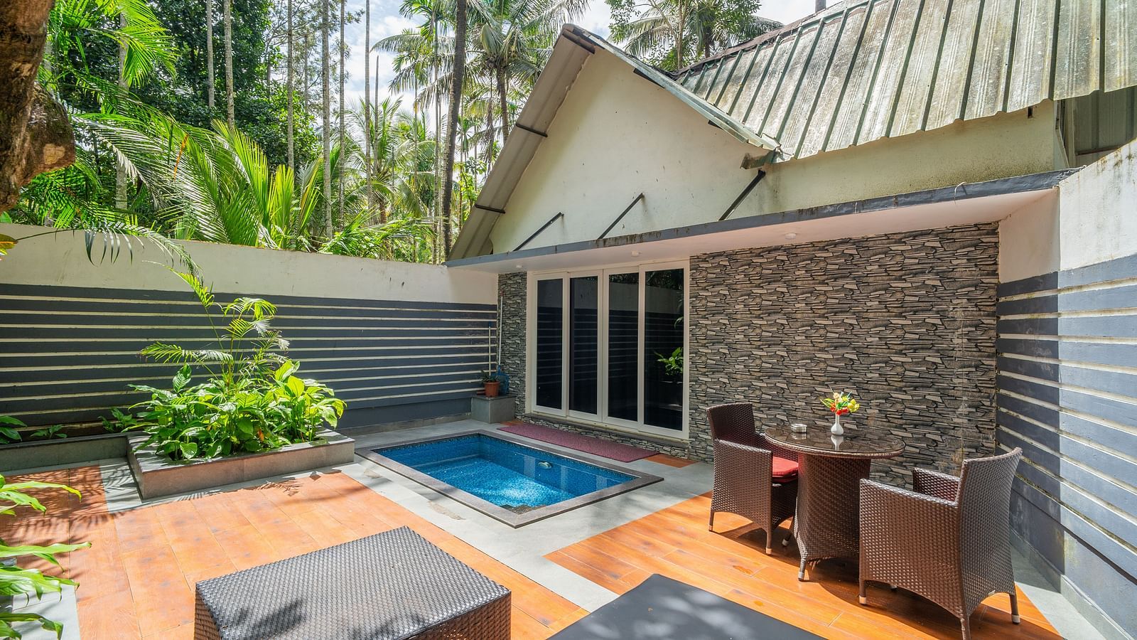 Facade of an accommodation with a swimming pool in front of it at Parampara Resort & Spa, Kushalnagar.