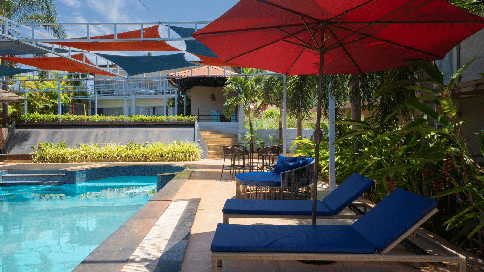 A sparkling swimming pool surrounded by sun loungers and a cosy seating area - Perfectstayz Koko Maya