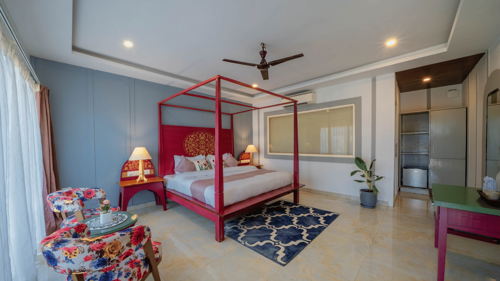 A room featuring a 4-poster king size bed with a rug, warm lighting from bedside lamps, and a seating area with chairs and a coffee table - Perfectstayz Koko Maya