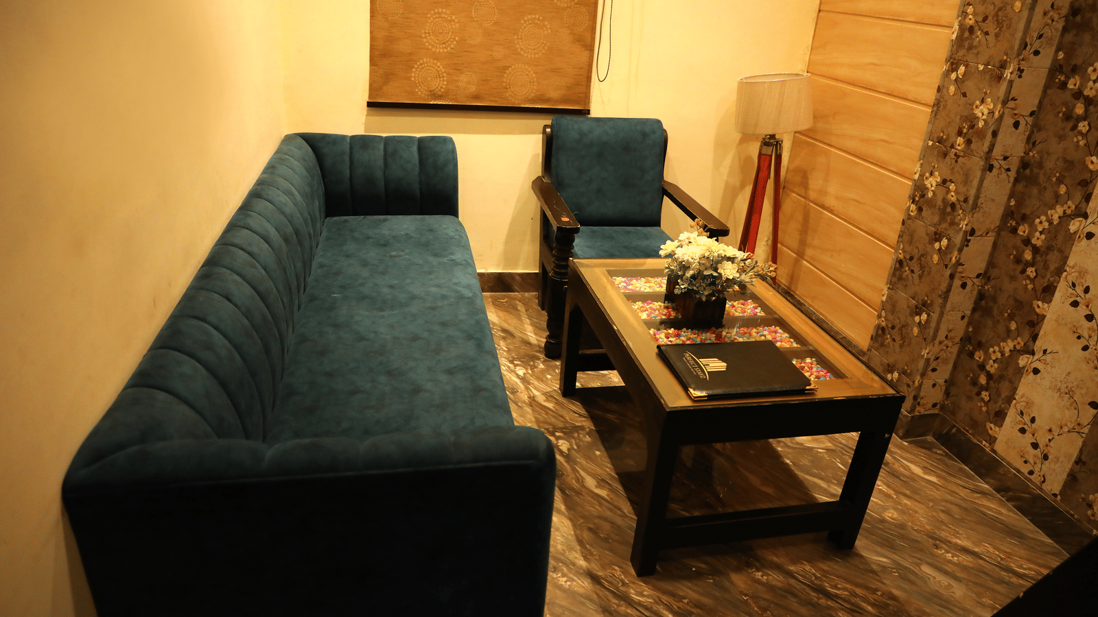 Interior of a living room showing a dark green sofa and coffee table in a lounge setting - Perfectstayz Premium at Har Ki Pauri Road (Ganga Heights)